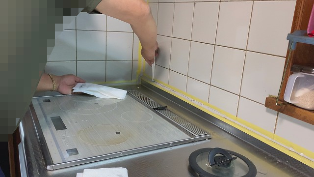 キッチン周りの壁は ・水はね ・油汚れ が飛びやすい場所です。 そのため、今回は壁紙ではなく アルミ複合板を使ってDIY施工することにしました。 一般的にはキッチンパネルを施工することが多いですが、 アルミ複合板でも十分代用できます。 しかも価格が安く、DIYでも施工しやすいのがメリットです。 今回使用した材料はこちらです。 ・アルミ複合板（3mm） ・両面テープ ・接着剤 施工した場所は ・シンク周り ・換気フード周り キッチンで特に汚れやすい部分に施工しました。 アルミ複合板は、両面テープで仮固定したあとに接着剤でしっかり固定します。 最後は隙間に 防カビシリコンでコーキングして仕上げました。 この方法なら、水や油が飛んでも掃除がしやすく キッチンの壁を清潔に保つことができます。 キッチンパネルよりコストも抑えられるので、 キッチンDIYリフォームにはおすすめの方法です。