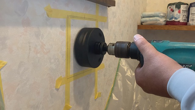 トイレ換気扇を後付けするため、110mmホルソーで室内側の壁に穴を開ける作業