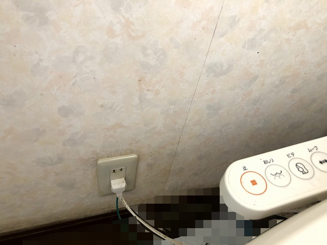 トイレ換気扇を後付けするため、既存コンセント近くの壁を取り付け位置に選んだ写真